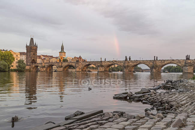 Arco iris sobre el puente Charles al atardecer, Praga, República Checa - foto de stock