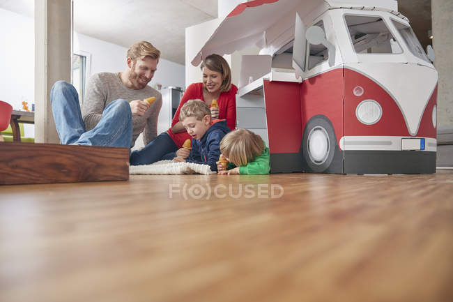 Felice famiglia mangiare gelato in soggiorno — Foto stock