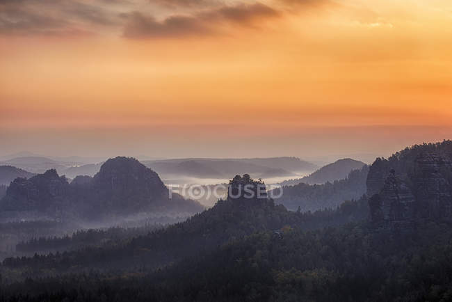 Germany, Saxony, Elbe Sandstone Mountains, view to Winterstein Mountain at sunrise — Stock Photo