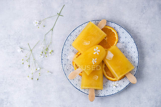 Dish with homemade orange popsicles — Stock Photo