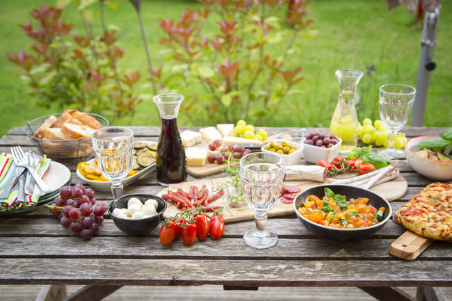 Variety of Mediterranean antipasti on garden table — Stock Photo