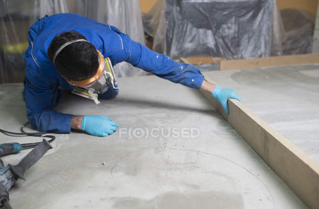 Worker checking the level of the concrete floor — Stock Photo