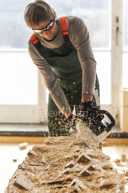 Holzschnitzer in der Werkstatt bearbeitet Holz für eine Skulptur mit der Kettensäge — Stockfoto