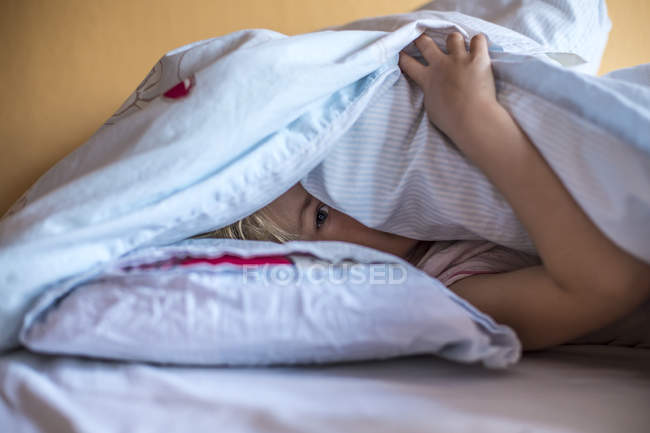 Под одеялом сестренкой. Девушка спряталась под одеялом. Девочка прячется под одеялом. Ребенок спрятался под одеялом. ПРЯТКИ под одеялом.