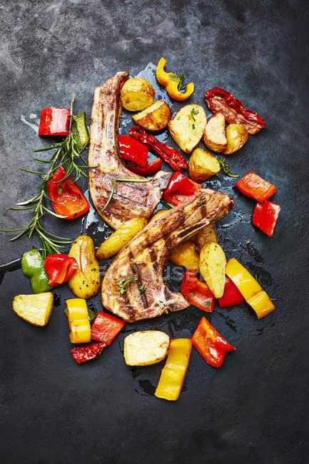 Costolette di agnello, patate e verdure da forno su ardesia — Foto stock
