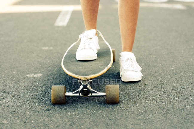 Jambes d'adolescente avec longboard — Photo de stock