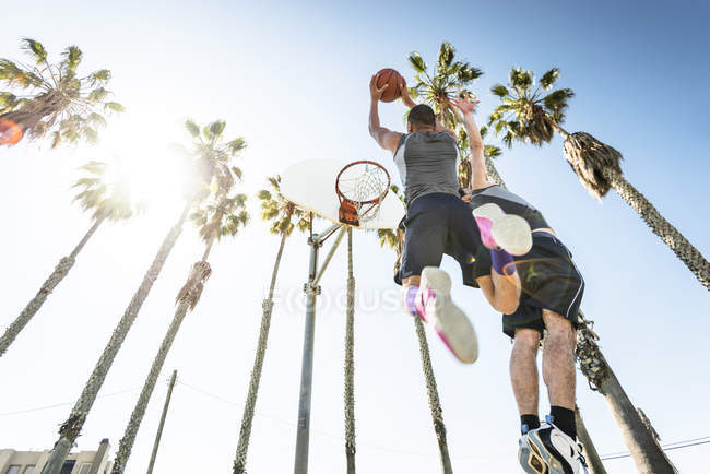 Two young men playing basketball on an outdoor court — Stock Photo