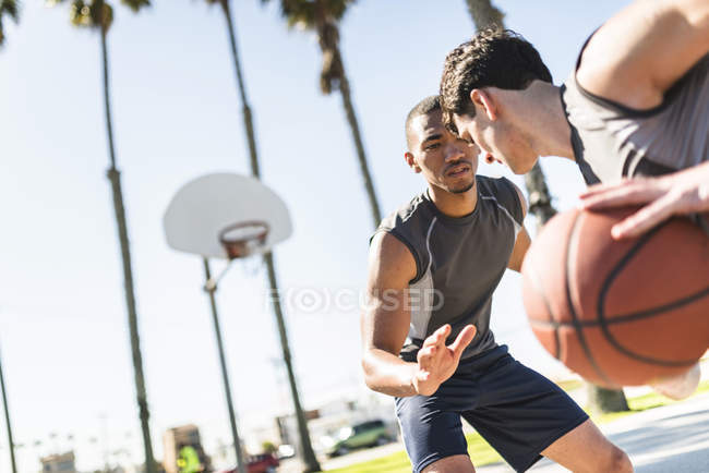 Zwei junge Männer spielen Basketball auf dem Außenplatz — Stockfoto