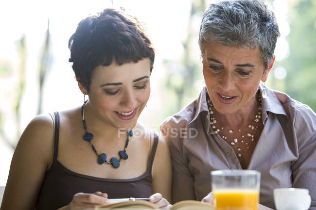 Mother and adult daughter sitting in pavement cafe — Stock Photo