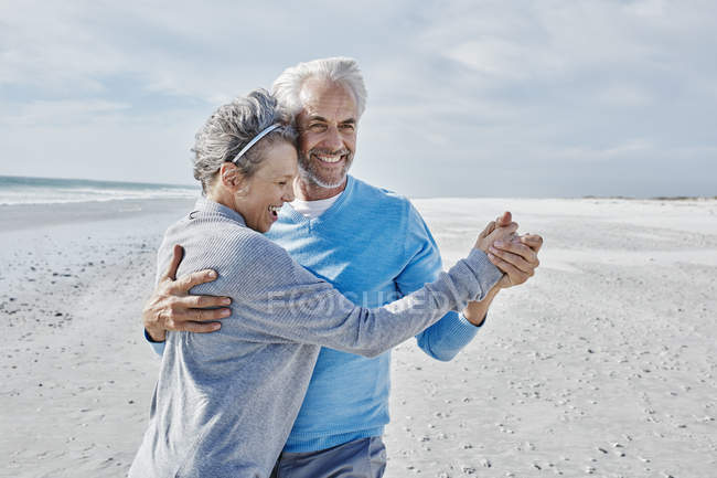Счастливая пара танцует на пляже — стоковое фото