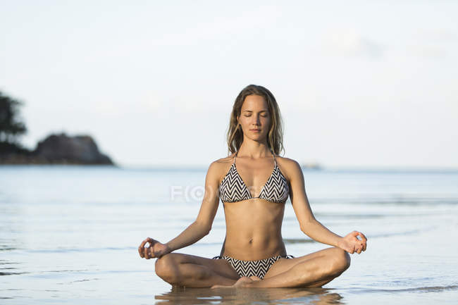 Thailand, woman meditating on beach — Stock Photo