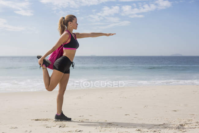 Mujer deportiva haciendo ejercicio en la playa - foto de stock