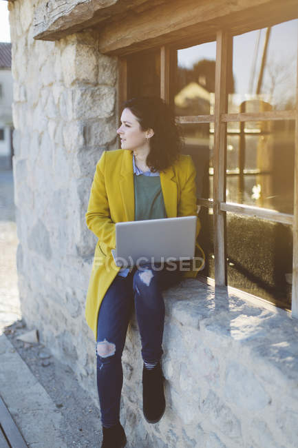 Mujer usando portátil fuera del edificio - foto de stock