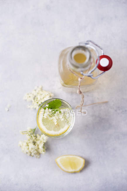 Glass of water flavoured with elderflower sirup and lemon — Stock Photo