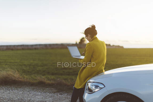 Frau benutzt Laptop im Auto — Stockfoto