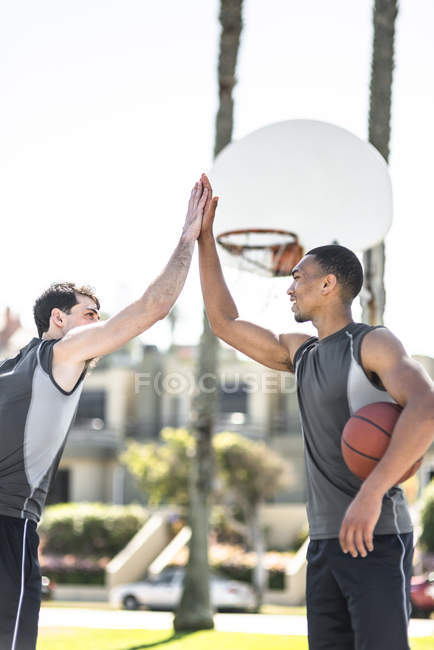 Zwei junge Männer beim High-Fiving auf Basketballfeld — Stockfoto
