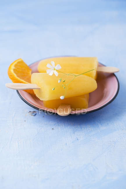 Bowl of homemade orange popsicles — Stock Photo