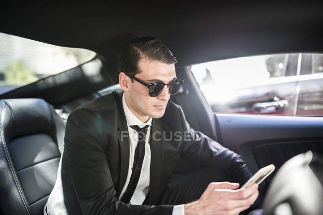 Geschäftsmann mit Handy im Auto — Stockfoto