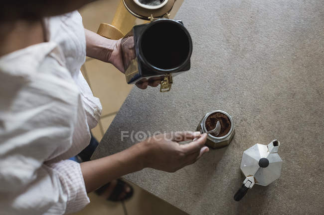 Junge Frau bereitet Espresso in der Küche zu, von oben gesehen — Stockfoto