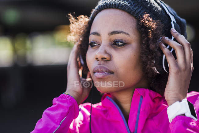 Junge Frau trägt Kopfhörer im Freien — Stockfoto