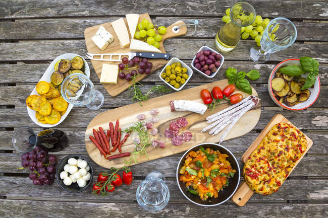 Variety of Mediterranean antipasti over wooden surface — Stock Photo