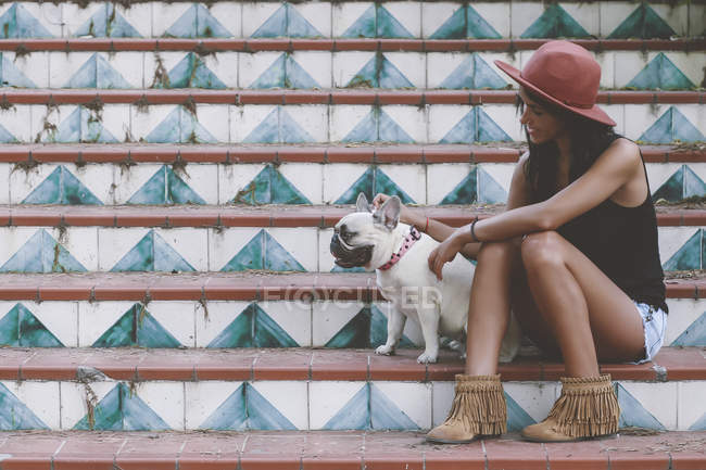 Femme assise avec son chien dans les escaliers — Photo de stock