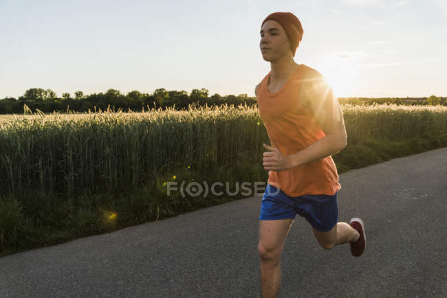 Молодой человек бегает против солнца — стоковое фото