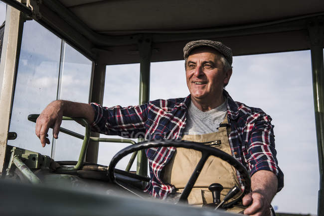 Portrait of smiling farmer on tractor — Stock Photo