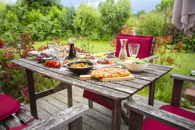 Variety of Mediterranean antipasti on garden table — Stock Photo
