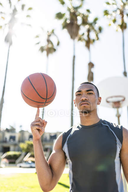Молодий чоловік, що тримає м'яч пальцем на баскетбол тренінг — стокове фото