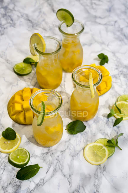 Fruit infused water with mango, lime and lemon — Stock Photo