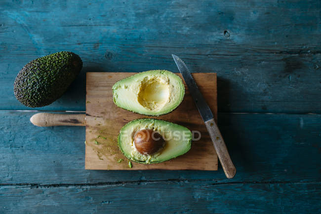 Whole and halved fresh avocado — Stock Photo