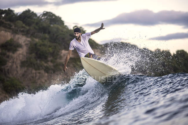 Indonesia, Sumbawa island, Surfer balancing on wave in ocean — Stock Photo