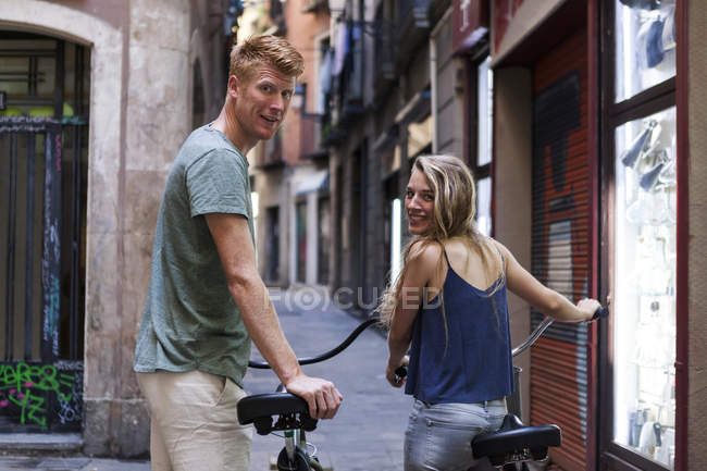 Spagna, Barcellona, coppia con biciclette davanti a un vicolo — Foto stock