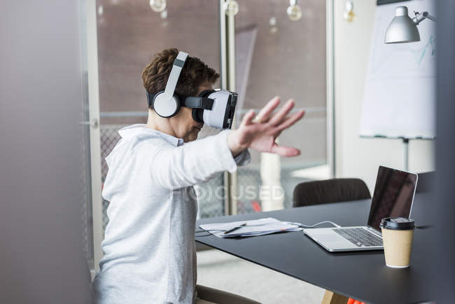 Woman in office wearing virtual reality glasses — Stock Photo
