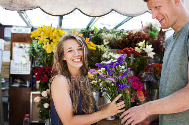 Homem presentear flores para namorada sorridente — Fotografia de Stock