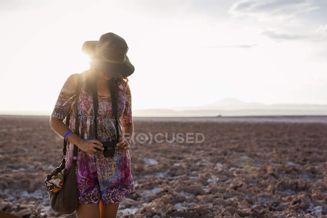 Mujer con cámara en el desierto - foto de stock
