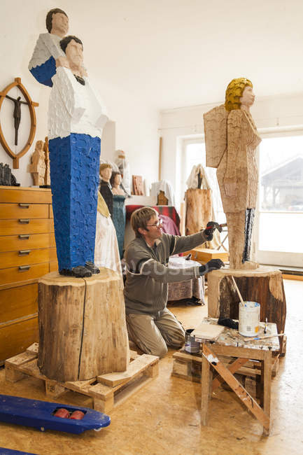 Intagliatore di legno in laboratorio pittura sua scultura — Foto stock