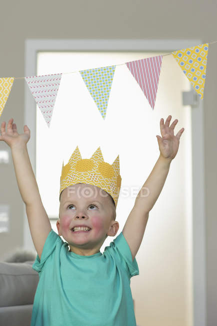 Felice ragazzo indossa corona di carta a casa — Foto stock