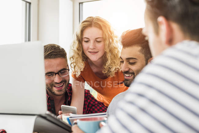 Selbstbewusste junge Berufstätige mit Handy im Büro — Stockfoto