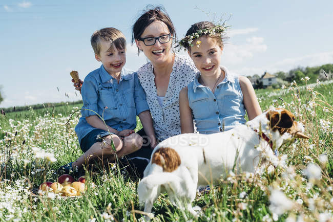 Madre y dos niños con perro - foto de stock