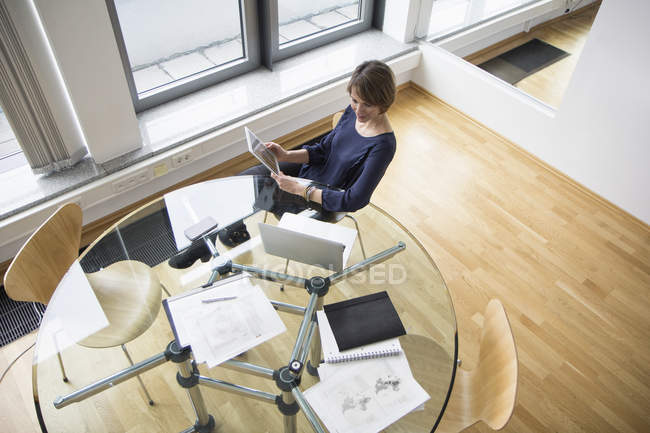 Geschäftsfrau mit digitalem Tablet und Laptop am Bürotisch — Stockfoto