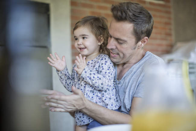 Padre e figlioletta applaudono a casa — Foto stock