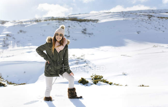 Sorridente giovane donna in montagne innevate — Foto stock