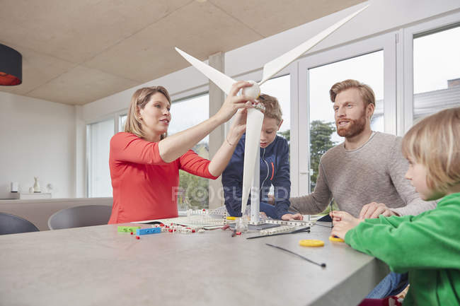 Семья собирает игрушечную ветряную турбину вместе — стоковое фото