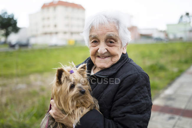 Retrato de mulher idosa com Yorkshire Terrier em seus braços — Fotografia de Stock