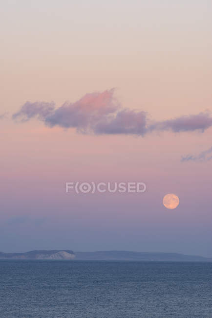 Royaume-Uni, Dorset, pleine lune au coucher du soleil sur l'eau — Photo de stock