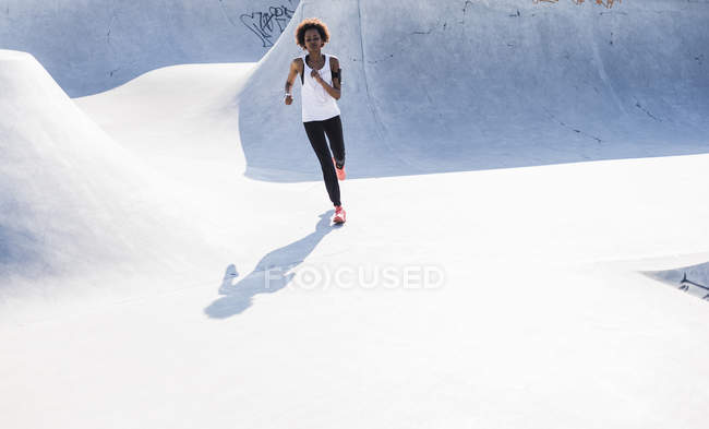 Young woman running in skatepark — Stock Photo