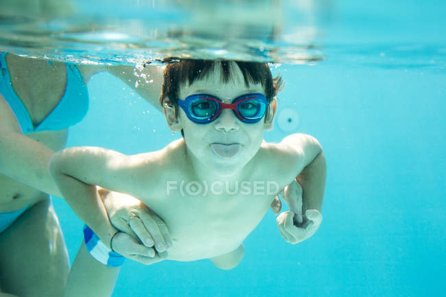 Little boy diving with mother underwater in swimming pool — together ...