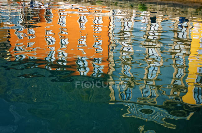 Italy, Lake Garda, Limone sul Garda, water reflections of colourful facades in harbour basin — Stock Photo